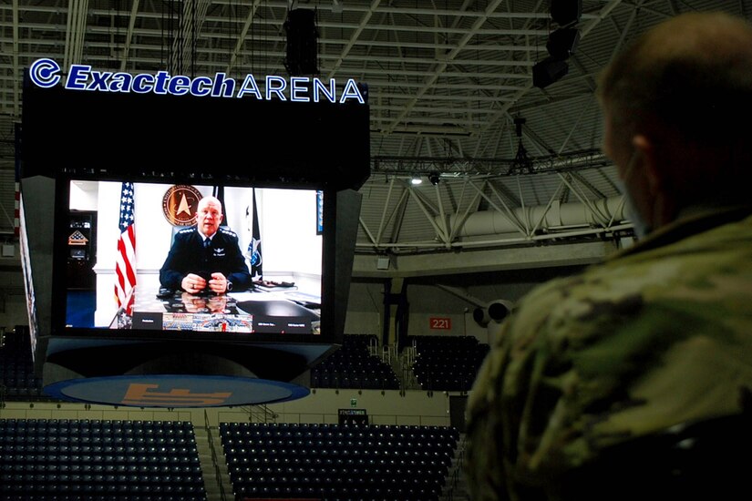 An officer speaks from a large monitor.