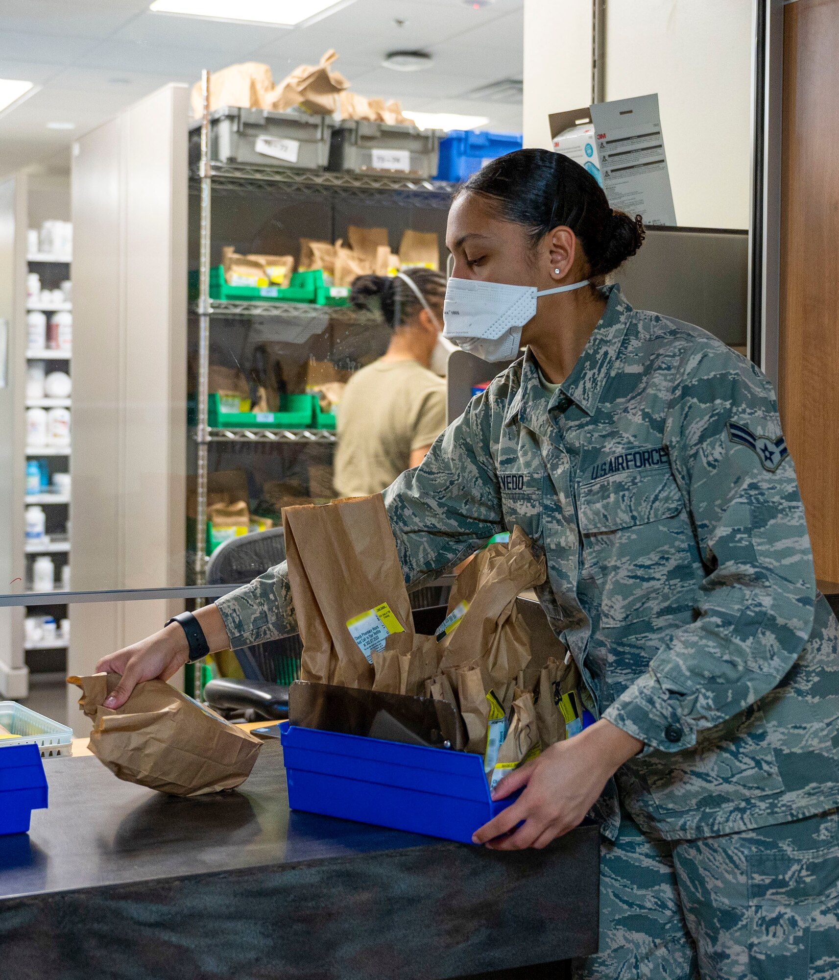 Airman 1st Class Mercedes Acevedo, 436th Medical Support Squadron pharmacy technician, grabs prescriptions to deliver to patients in the 436th Medical Group parking lot as part of the Park N’ Pickup system at Dover Air Force Base, Delaware, March 12, 2021. The Park N’ Pickup system is a limited contact prescription delivery process established to ensure the safety of both patients and workers and help mitigate the spread of COVID-19. (This photo has been digitally enhanced to protect patient information) (U.S. Air Force photo by Airman 1st Class Cydney Lee)