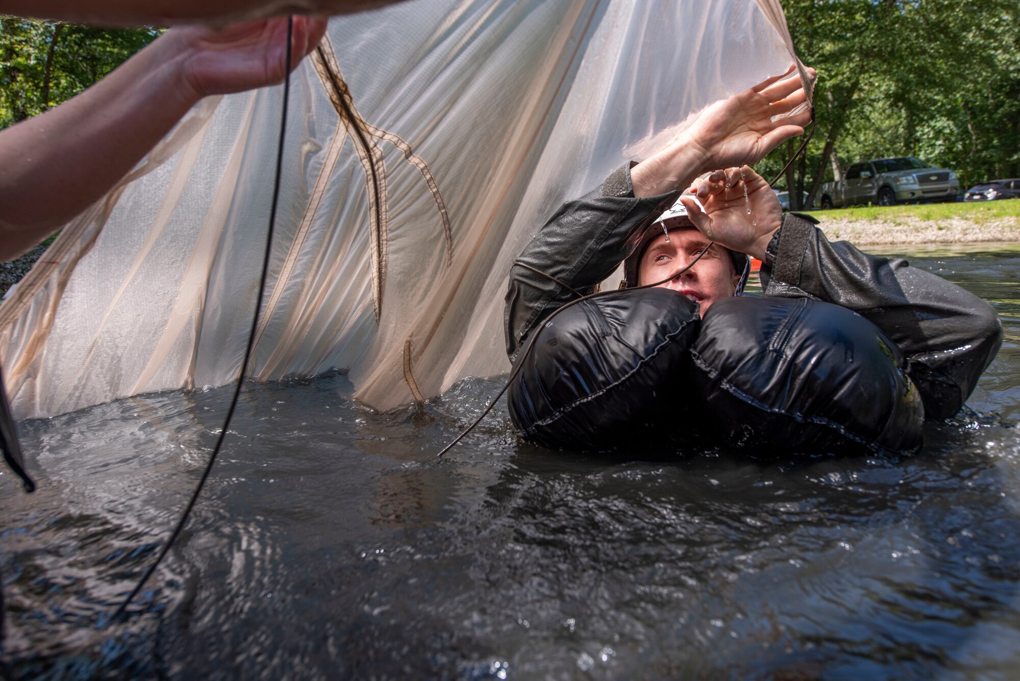 U.S. Air Force Capt. Kyle Russell, an F-16 fighter pilot assigned to the Ohio National Guard's 180th Fighter Wing, swims under an open parachute during water survival training in Waterville, Ohio, Aug. 8, 2020.