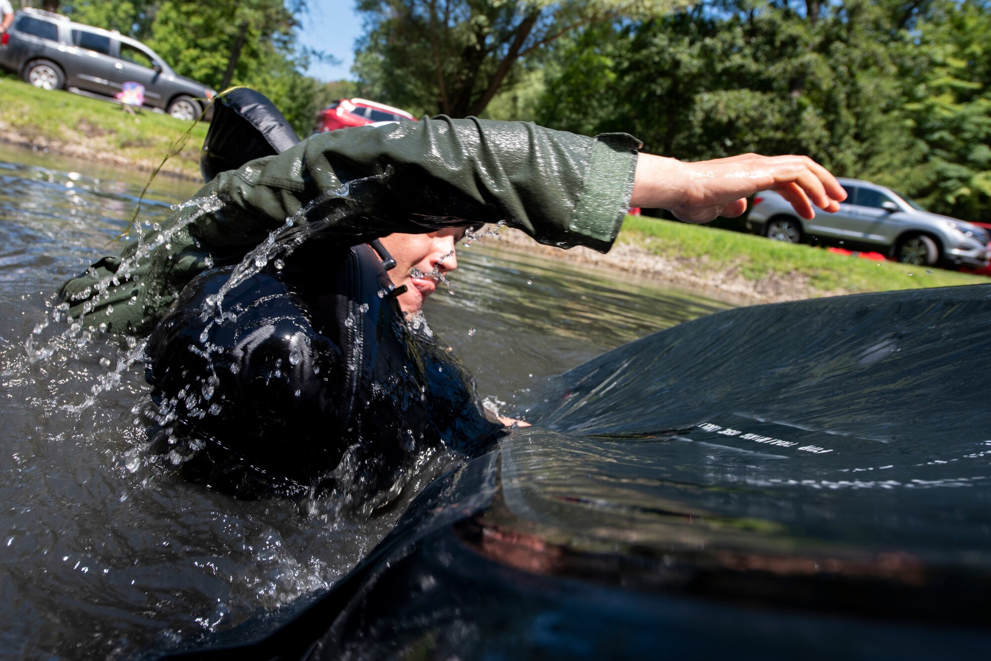 U.S. Air Force Capt. Jacob Laginess, an F-16 fighter pilot assigned to the Ohio National Guard's 180th Fighter Wing, flips a life raft over during water survival training in Waterville, Ohio, Aug. 8, 2020.