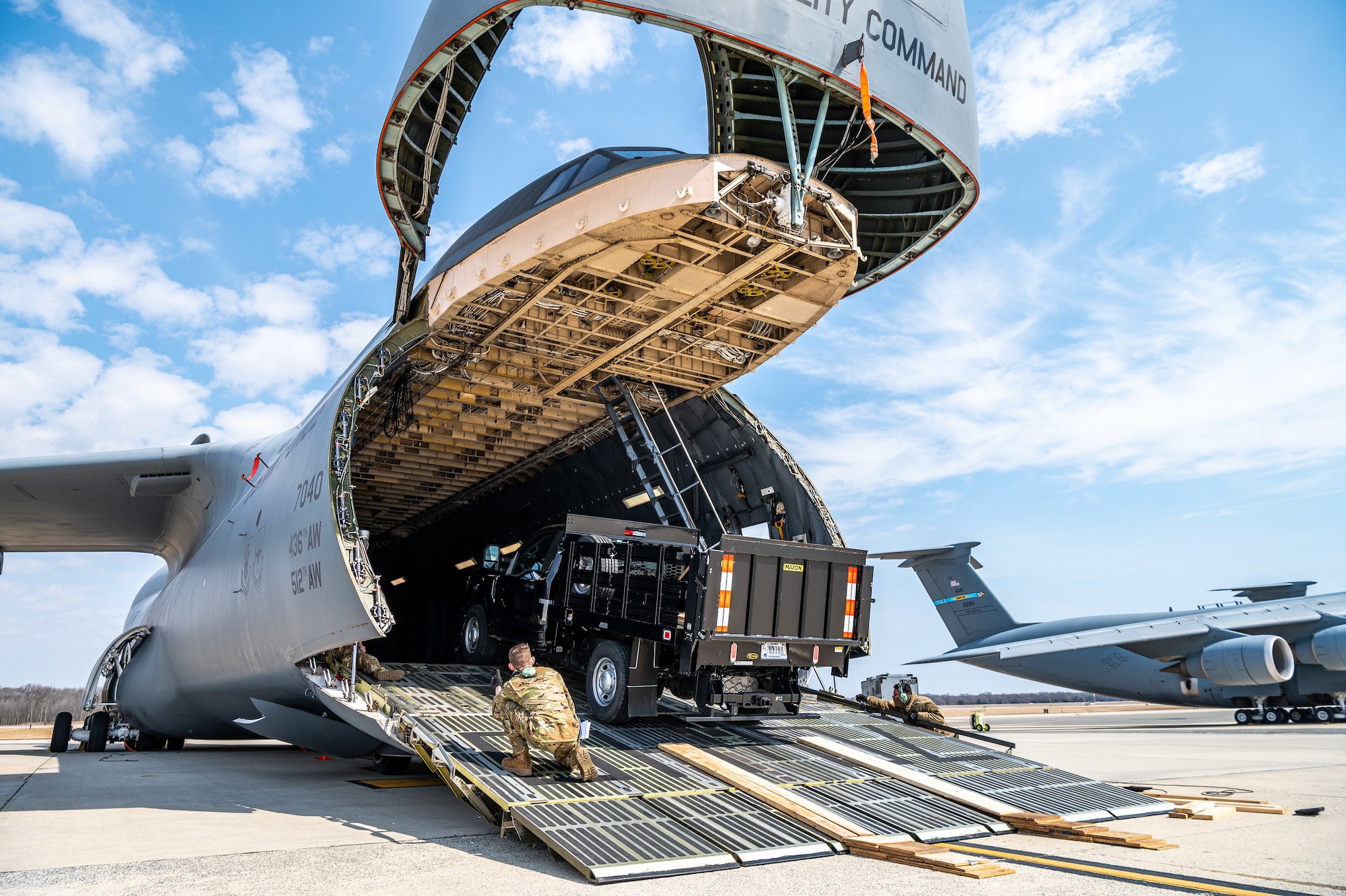 A stake-bed truck is loaded onto a C-5M Super Galaxy during loadmaster training at Dover Air Force Base, Delaware, March 9, 2021. Loadmasters from the 9th Airlift Squadron participated in the training as part of a Major Command Service Tail Trainer initiative driven by Air Mobility Command. The training expedites C-5 loadmaster upgrade training, enabling Dover AFB to provide rapid global airlift. (U.S. Air Force photo by Senior Airman Christopher Quail)
