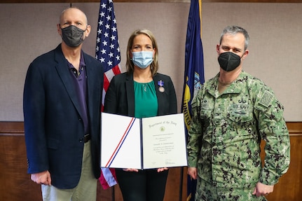 Chemical, Biological, Radiological Defense Protection and Integration Branch Head Danielle Zimmerman receives the DON Meritorious Civilian Service Award from Naval Surface Warfare Center Indian Head Division Commanding Officer Capt. Eric Correll and Technical Director Ashley Johnson during a presentation onboard NSWC IHD, March 25. Zimmerman received the award for her role in her division’s transfer from NSWC Dahlgren Division to NSWC IHD.