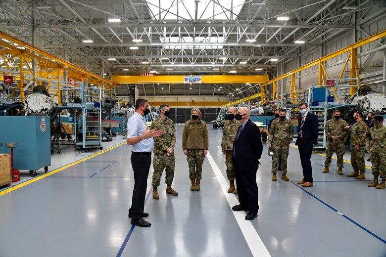 Braeden Stander (front left), 573rd Aircraft Maintenance Squadron director, briefs Acting Secretary of the Air Force John Roth (front right), and other leaders.