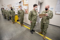 Capt. Jip Mosman, commander, Puget Sound Naval Shipyard & Intermediate Maintenance Facility, visits with Sailor of the Year awardee Petty Officer 1st Class Joshua Moulton March 19, 2021, during a tour of Detachment Everett at Naval Station Everett, Washington.