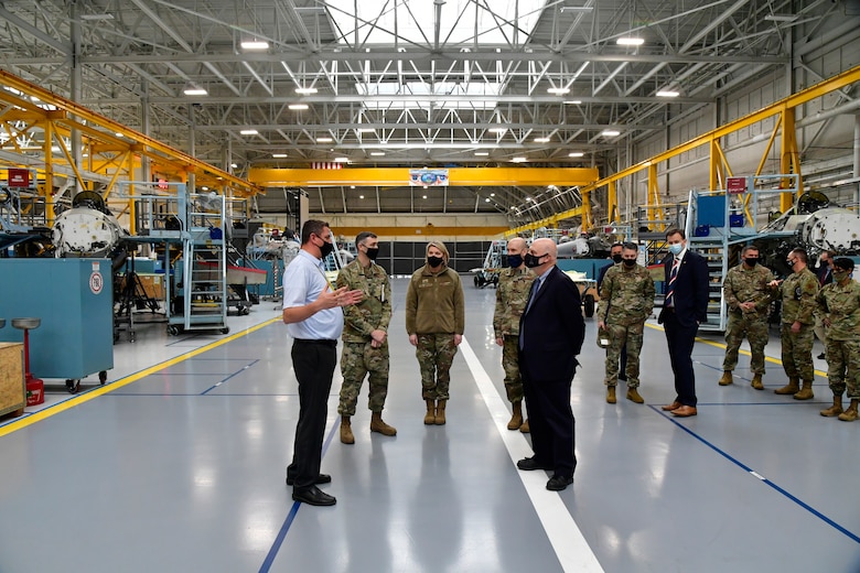 Braeden Stander (front left), 573rd Aircraft Maintenance Squadron director, briefs Acting Secretary of the Air Force John Roth (front right), and other leaders.