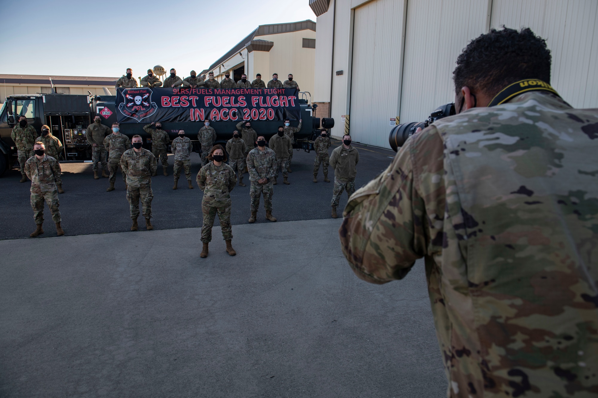 Staff Sgt. Collville McFee, 9th Reconnaissance Wing photojournalist, right, takes a photo of Chief Master Sgt. of the Air Force JoAnne Bass and the 9th Logistics Readiness Squadron’s petroleum, oil and lubricant (POL) flight on Beale Air Force Base.