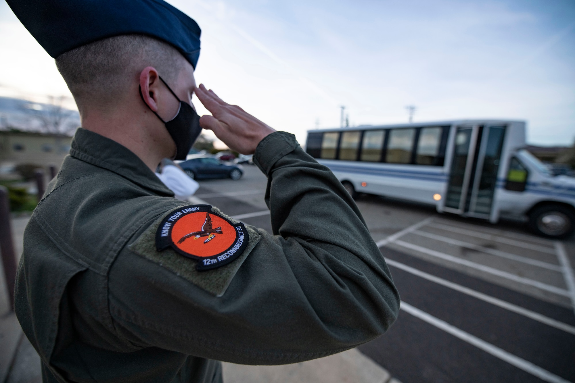 An airman from the 12th Reconnaissance Squadron (RS) salutes the bus carrying Chief Master Sgt. of the Air Force JoAnne Bass as it arrives at a dining facility on Beale Air Force Base.