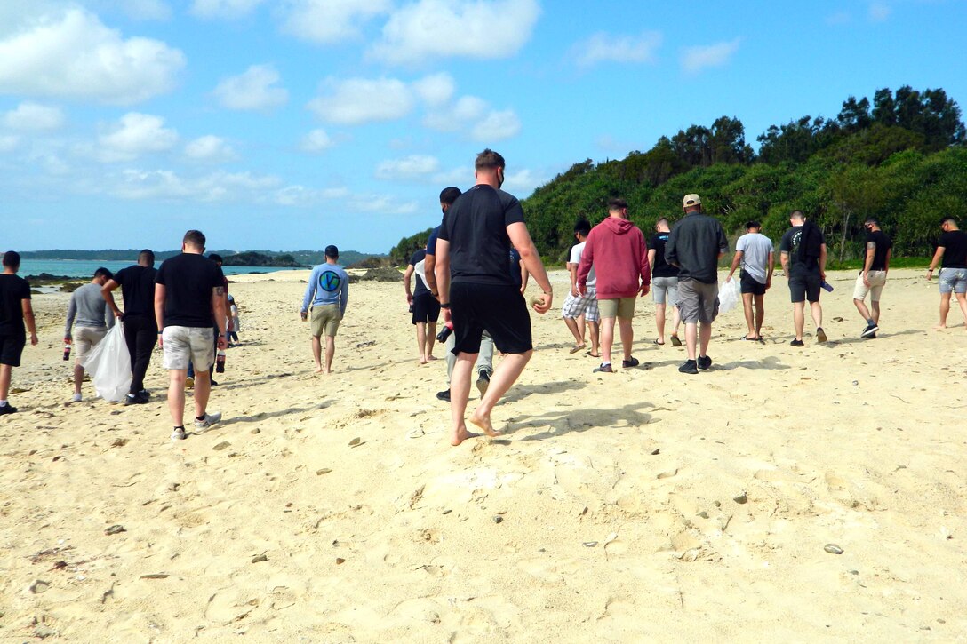 伍長コースで学ぶ海兵隊員らがシーグラスビーチで、横一列に広がり、ビーチに流れ着いたペットボトルやプラスティック容器などの様々なゴミを拾い集めました。2021年３月25日、豊原区シーグラスビーチ