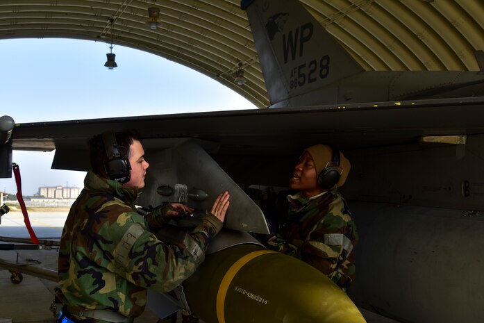 Senior Airman Babij Matthew and Staff Sgt. Samill Harkness, 35th Aircraft Maintenance Unit load crew members, turn jets during a routine training event at Kunsan Air Base, Republic of Korea, March 23, 2021. The F-16 Fighting Falcons landed and quickly refueled before taking off for another sortie.  (U.S. Air Force photo by Tech. Sgt. Kristin S. High)