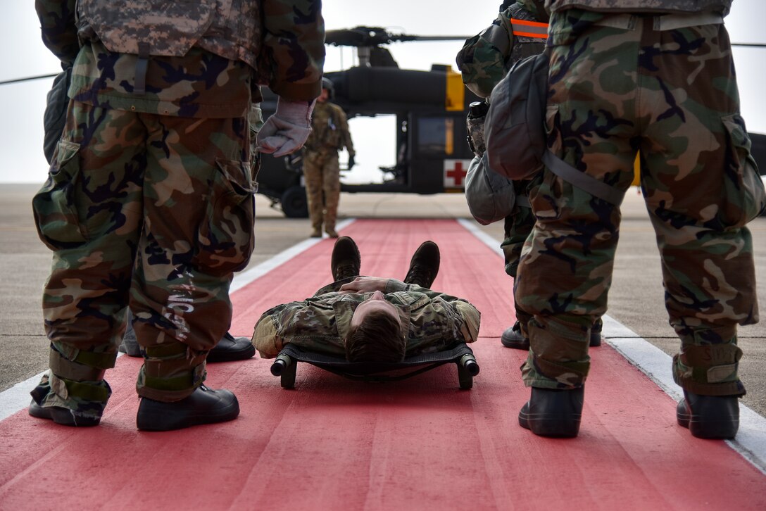 Eighth Medical Group Airmen prepare to perform a litter carry during a routine medical evacuation training event at Kunsan Air Base, Republic of Korea, March 25, 2021. The interagency training involved the 8th Medical Group “Med Hawks” and the 3-2 General Support Aviation Battalion from Camp Humphreys. (U.S. Air Force photo by Senior Airman Suzie Plotnikov)