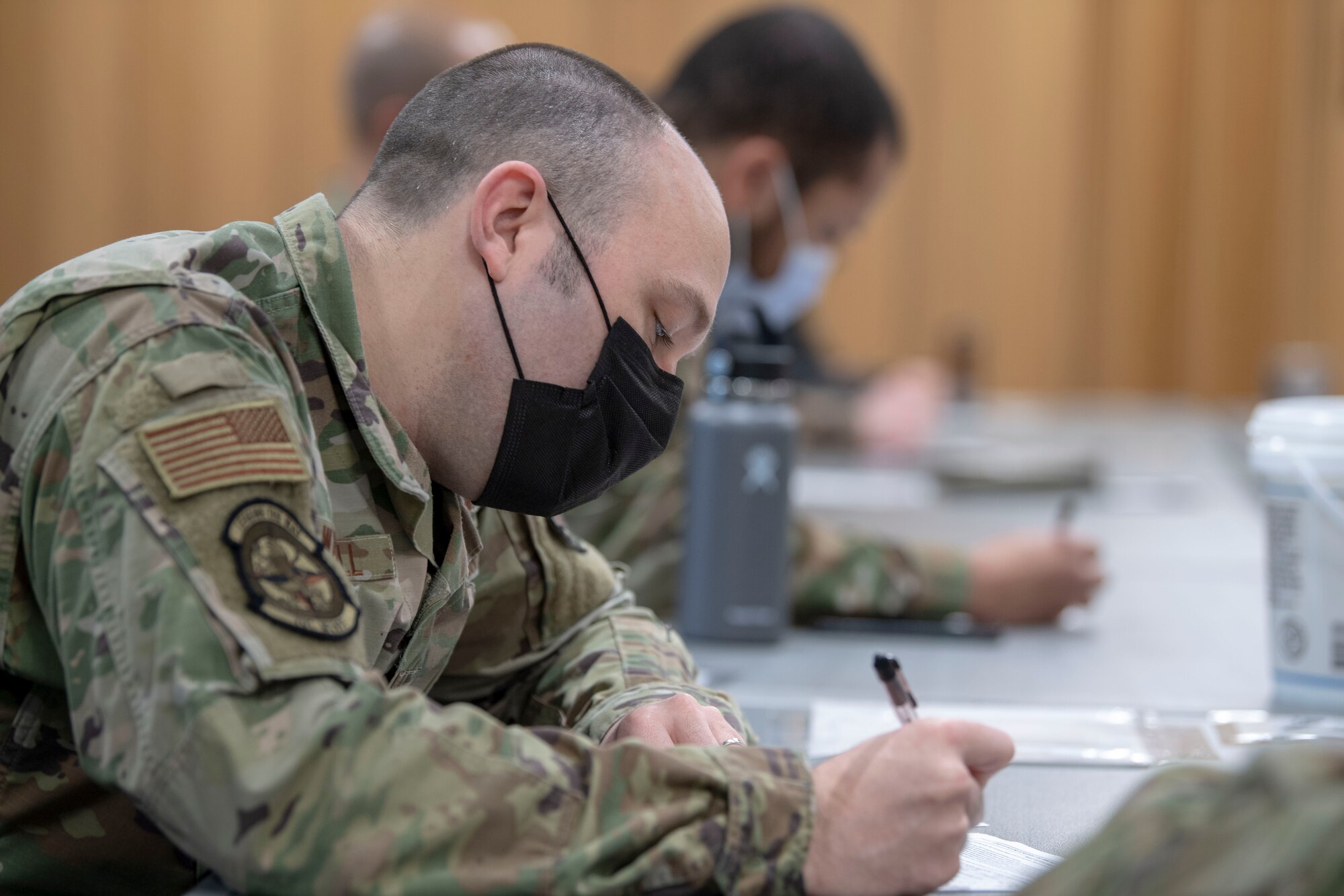 Airmen assigned to the 701st Munitions Maintenance Squadron complete paperwork before being administered the COVID-19 vaccine at Kleine Brogel Air Base, Belgium, March 19, 2021. These vaccines were administered by independent duty medical technicians who are responsible for providing all the medical care for members assigned to the 701st MUNSS. (U.S. Air Force photo by Senior Airman Alex Miller)