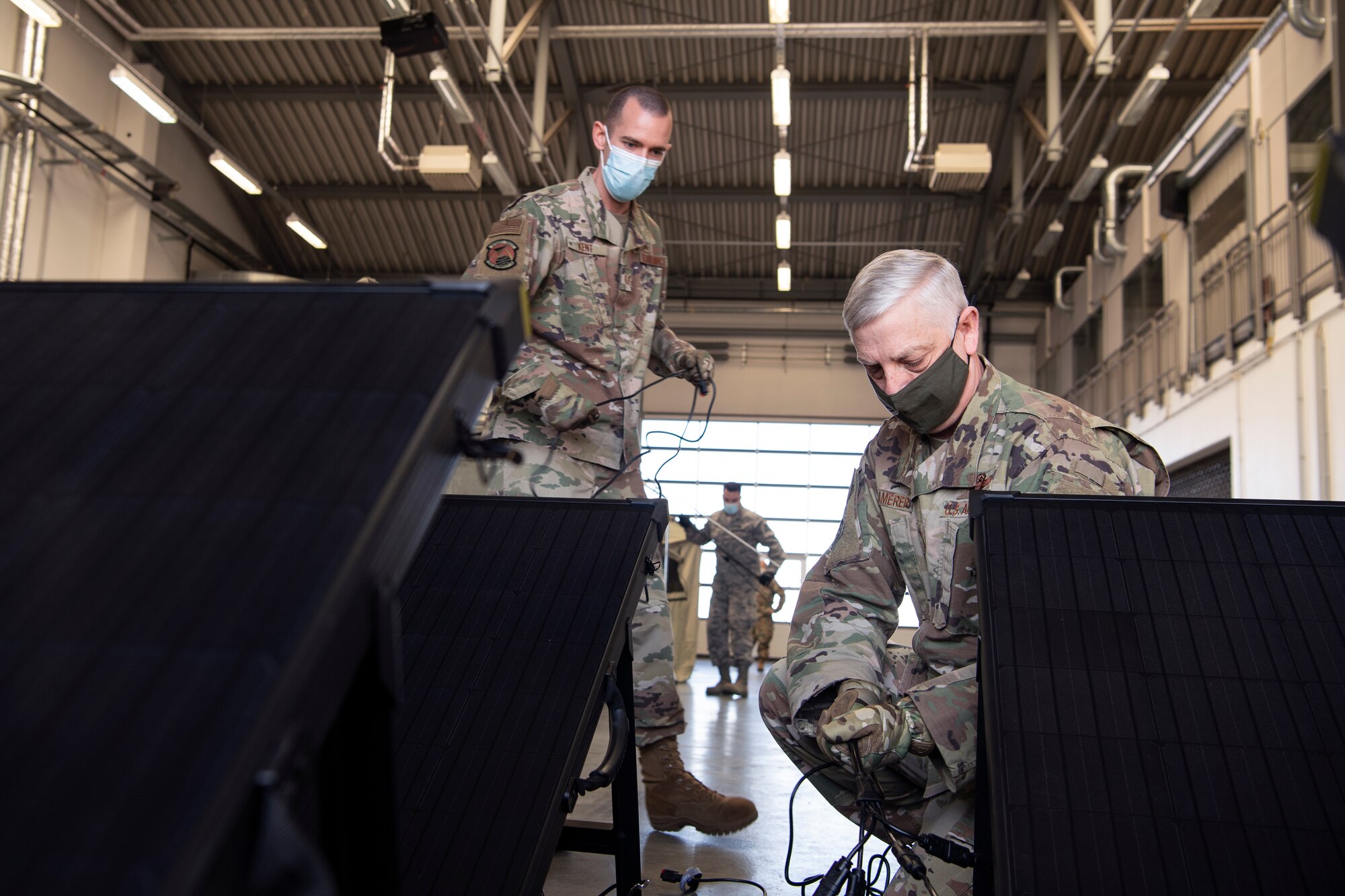 An Airman shows another Airman solar panels.