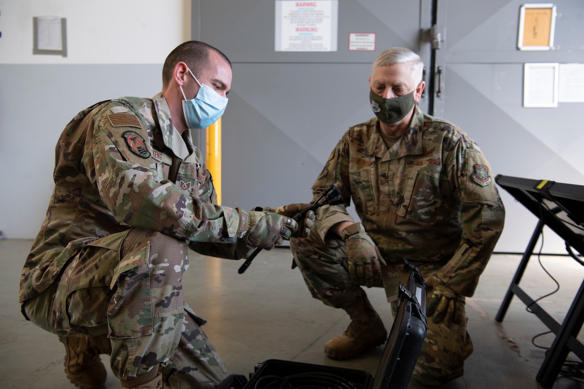 An Airman shows another Airman how to set up solar panels.