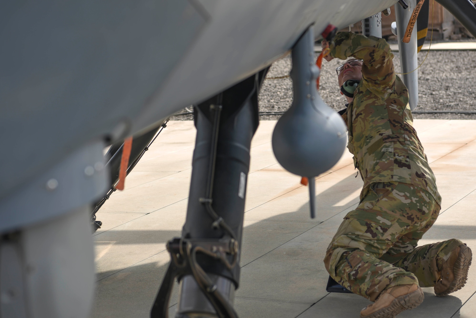 A U.S. Air Force remotely piloted aircraft pilot assigned to the 12th Expeditionary Special Operations Squadron, performs a pre-flight inspection on a MQ-9 unmanned aviation aircraft at Chabelley Airfield, Djibouti, March 19, 2021. The 12th ESOS provides intelligence, surveillance and reconnaissance across the Combined Joint Task Force - Horn of Africa’s area of responsibility. (U.S. Air Force photo by Staff Sgt. Matthew J. Wisher)