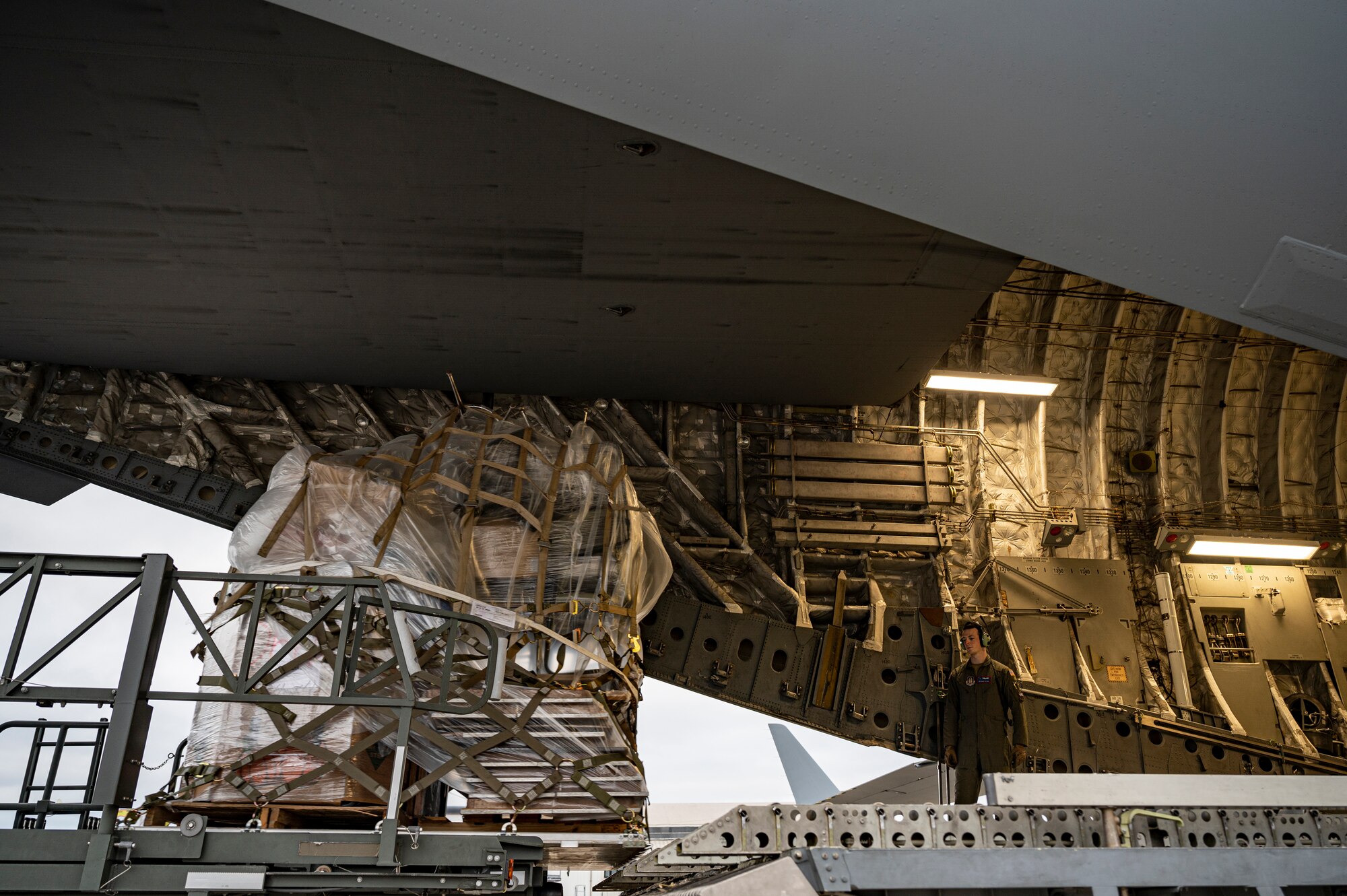 An Airman assigned to Joint Base Charleston ensures the humanitarian aid for the Denton Program is lined up correctly with rollers in a C-17 Globemaster III at the Pittsburgh International Airport Air Reserve Station, Pennsylvania, March 11, 2021.