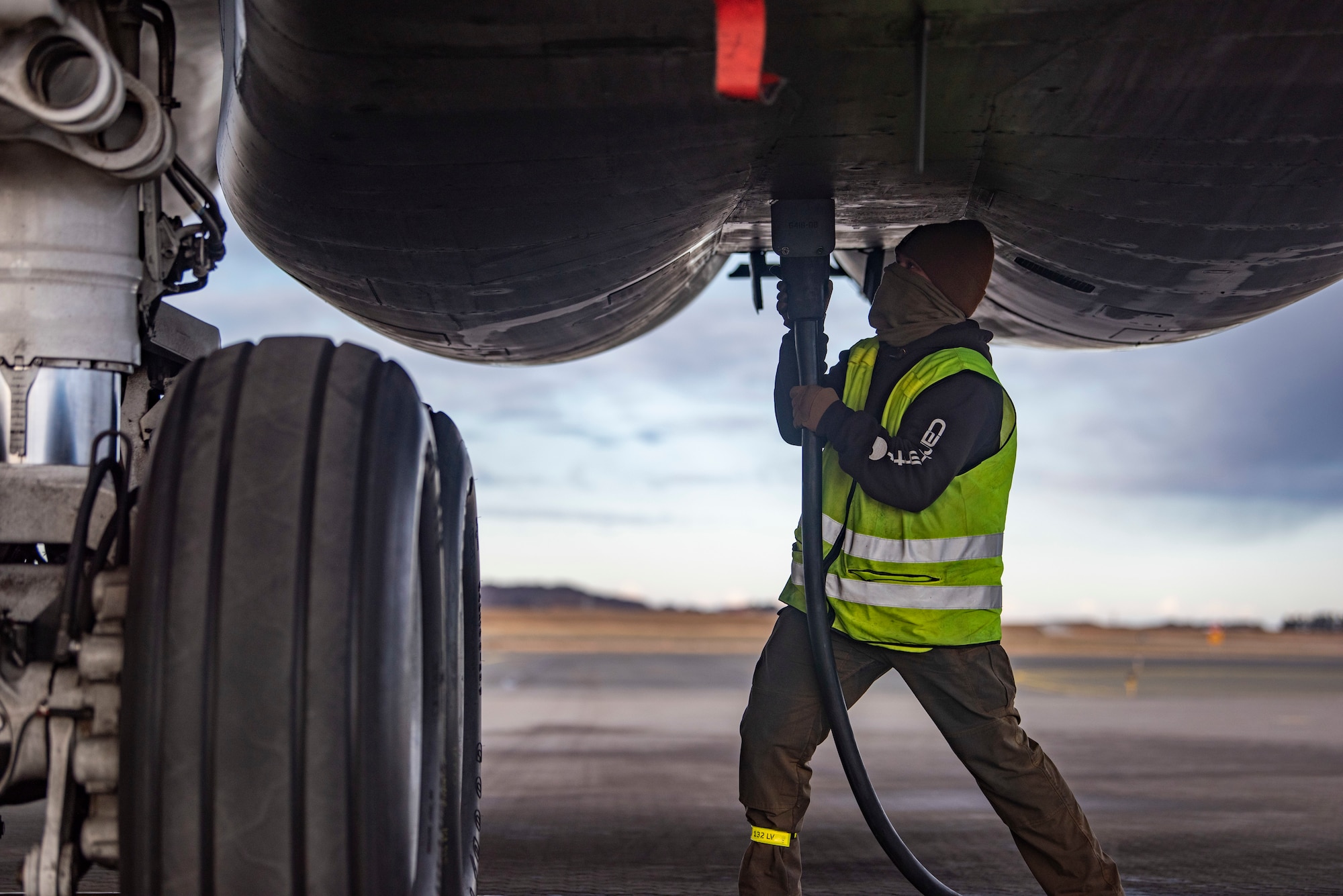 A crew chief assigned to the 9th Expeditionary Bomb Squadron connects a generator cord into a B-1B Lancer at Ørlans Air Force Station, Norway, March 13, 2021. The generator is responsible for charging batteries on the aircraft while servicing the accumulators needed to start the auxiliary power unit. (U.S. Air Force photo by Airman 1st Class Colin Hollowell)