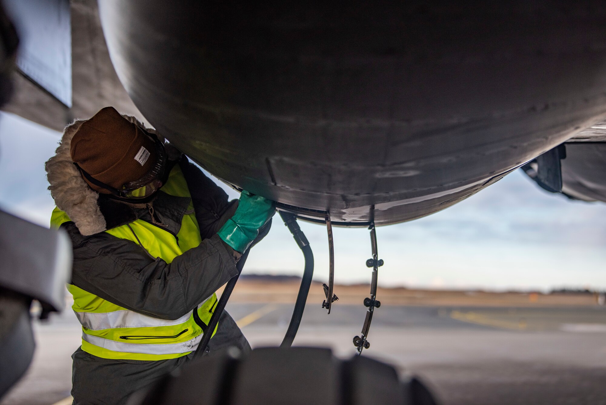 A crew chief assigned to the 9th Expeditionary Bomb Squadron services the oil on a B-1B Lancer at Ørland Air Force Station, Norway, March 13, 2021. Aircraft undergo routine servicing to ensure the plane is safe to perform missions. (U.S. Air Force photo by Airman 1st Class Colin Hollowell)