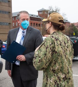 Acting Secretary of the Navy Thomas W. Harker is presented a memento by Shipyard Commander Capt. Dianna Wolfson at the conclusion of his visit to Norfolk Naval Shipyard March 17. Secretary Harker toured NNSY as part of a visit to the Mid-Atlantic region.