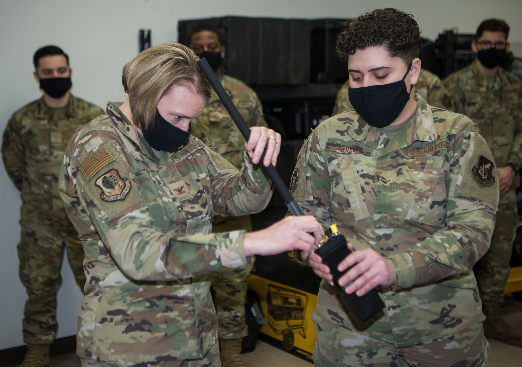 U.S. Air Force Col. Kirsten Aguilar, Joint Base Elmendorf-Richardson and 673d Air Base Wing commander and U.S. Air Force Airman 1st Class Amber Rios, a 673d Communications Squadron cyber control operator, go over radio procedures during an immersion tour at JBER, Alaska, March 19, 2021. The focus of Aguilar’s tour was to get to know the 673d CS Airmen and familiarize herself with the squadron’s different sections and each one’s role in supporting the base.