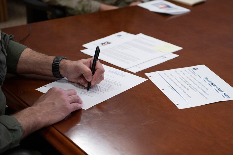 A photo of an Airman signing a paper.