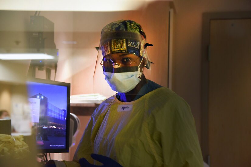 A female soldier works at a hospital computer.