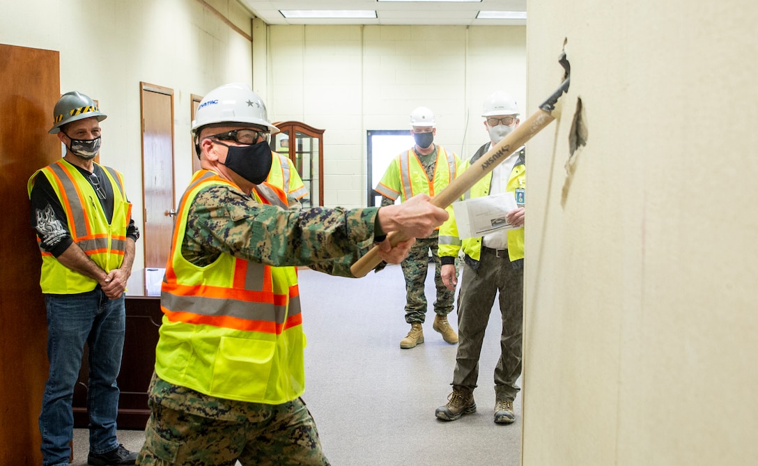 U.S. Marine Corps Lt. Gen. Robert F. Hedelund, Commanding General, Fleet Marine Force Atlantic, and Commander, U.S. Marine Corps Forces Command, U.S. Marine Corps Forces Northern Command swings a sledgehammer at a wall in the Marine Camp Elmore (MCE-9) building at Camp Elmore in Norfolk, Virginia, March 24, 2021. This event signifies the start of converting previously used training rooms, classrooms, and administrative offices into fully-functioning, mission-capable headquarters spaces in support of the Commandant’s force restructure initiatives. The interior reconfiguration will accommodate the new P&O, South detachment. The upgraded administrative workspaces will be occupied by personnel assigned to manpower, reserve integration, plans, forward-deployed plans and execution, global force analysis, aviation force analysis, and readiness functions. The renovation is slated to be complete in August of 2021. (U.S. Marine Corps Photo by Mr. Jonathan Donnelly/Released)