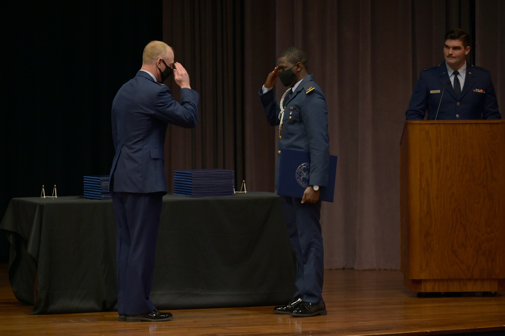 Col. Seth graham (right), 14th Flying Training Wing commander, returns a salute from 1st Lt. Abubakar Alkali, international student pilot graduate, March 26, 2021, on Columbus Air Force Base, Miss. In the primary phase of training, students learn basic aircraft control, including takeoff and landing techniques and aerobatics in all types of weather to several different locations. (U.S. Air Force photo by Senior Airman Jake Jacobsen)