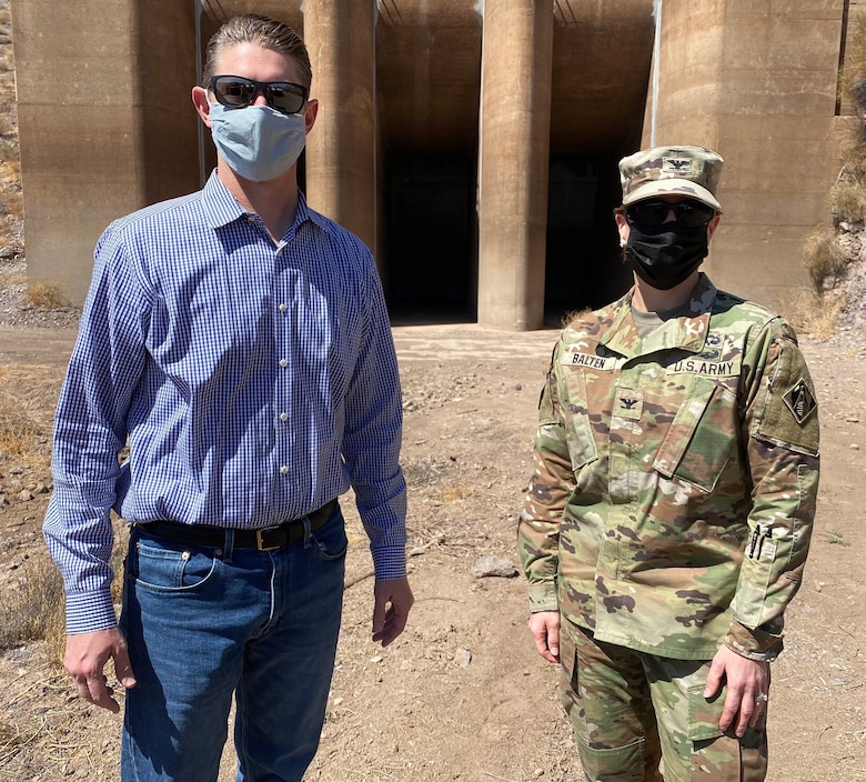 Col. Julie Balten, commander of the U.S. Army Corps of Engineers Los Angeles District, right, and David Van Dorpe, deputy district engineer for the LA District, left, visit Painted Rock Dam March 24 near Gila Bend, Arizona. The inflow gates, pictured behind Balten and Van Dorpe, regulate the amount of river water released downstream.