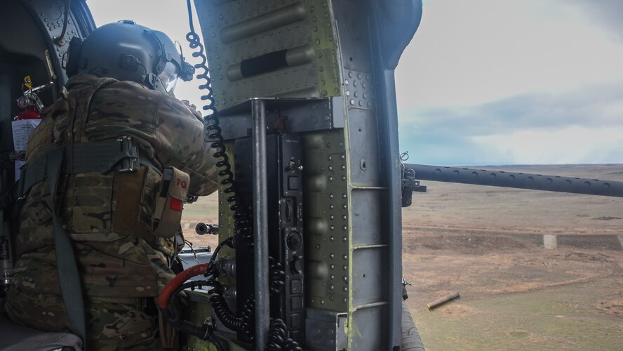A man in a helicopter fires a .50-caliber machine gun
