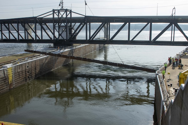 Personnel from the U.S. Army Engineer Research and Development Center and U.S. Geological Survey watch as a 350-ton crane lowers the 105-foot-long weldment, or underwater Acoustic Deterrent System, into the lock approach of Lock 19 near Keokuk, Iowa, Feb. 3, 2021. Laboratory-tested sounds that proved to be irritating to invasive Asian carp will be broadcast underwater from the weldment as part of a study to evaluate fish behavior.