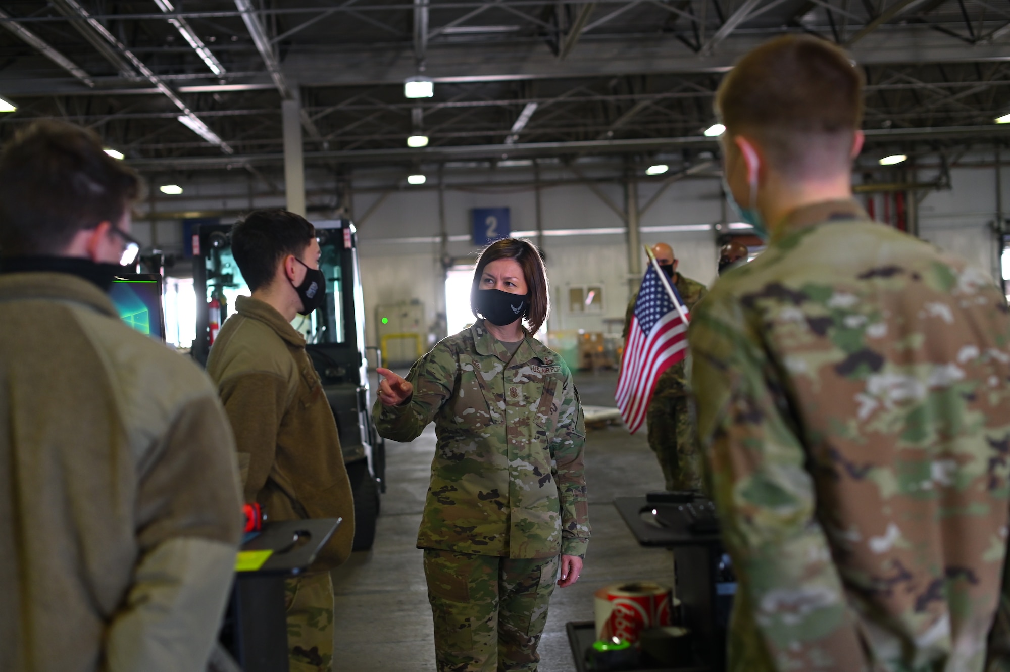 Chief Master Sergeant of the Air Force JoAnne S. Bass talks with Airmen assigned to the 60th Aerial Port Squadron March 25, 2021, at Travis Air Force Base, Calif. Bass visited Travis AFB to meet the Airmen who demonstrate innovative thinking and enhance the rapid global mobility mission.