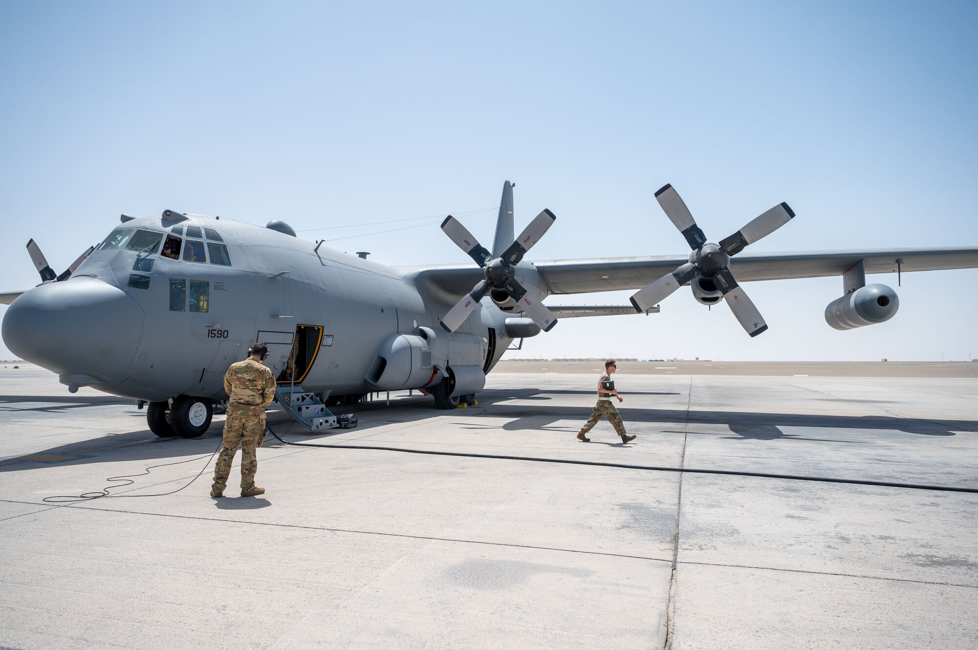 U.S. Airmen perform pre-flight checks on an EC-130H Compass Call