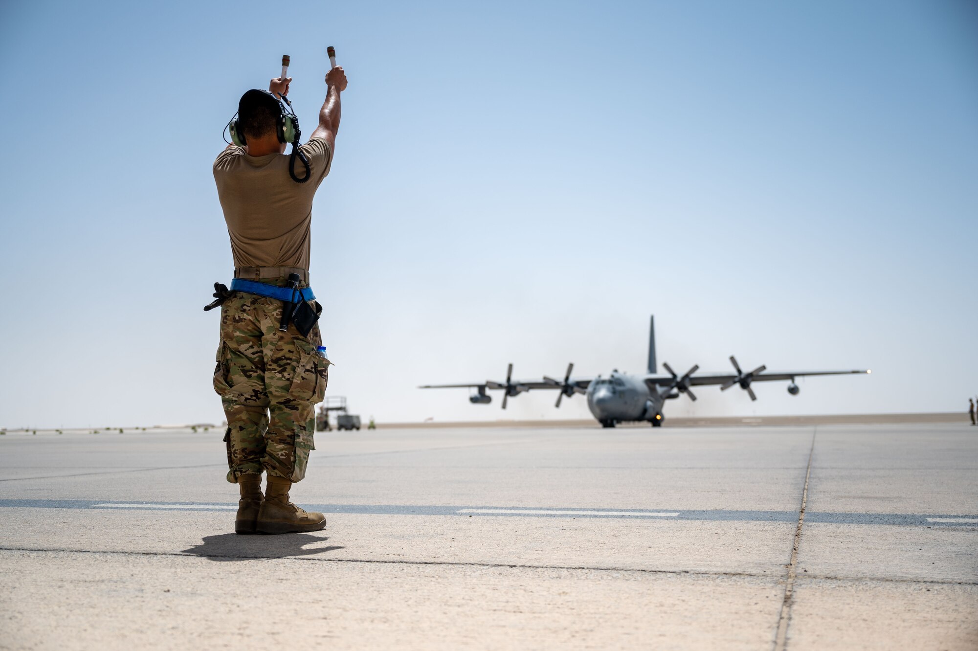 Senior Airman Caleb Palompo marshals out an EC-130H Compass Call.