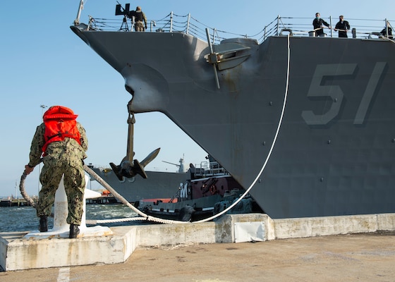 A Sailor removes a mooring line from a bollard to assist the guided-missile destroyer USS Arleigh Burke (DDG 51) in getting underway from Naval Station Norfolk on March 26.