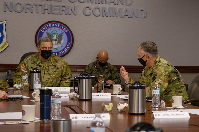 Military personnel hold a discussion with a general.