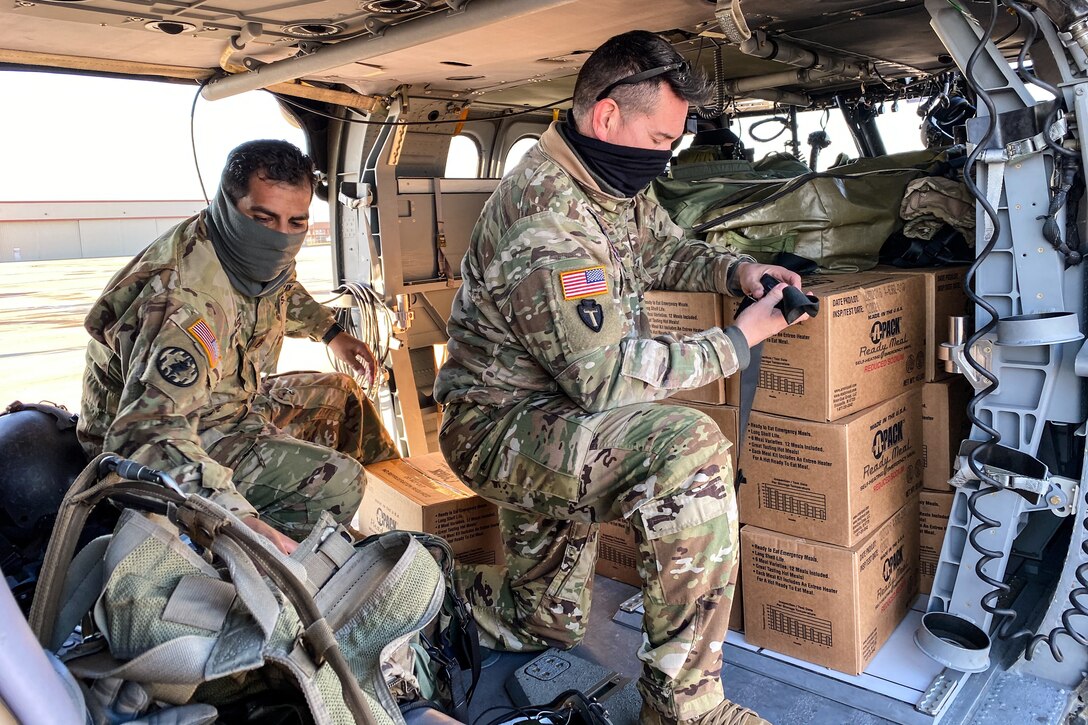 Soldiers load supplies on an aircraft.