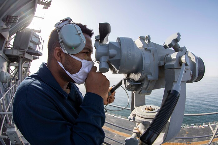 Operations Specialist Seaman Dave Desir monitors maritime traffic while standing lookout watch as amphibious assault ship USS Makin Island (LHD 8) arrives Duqm, Oman, for a maintenance and sustainment visit, March 23.