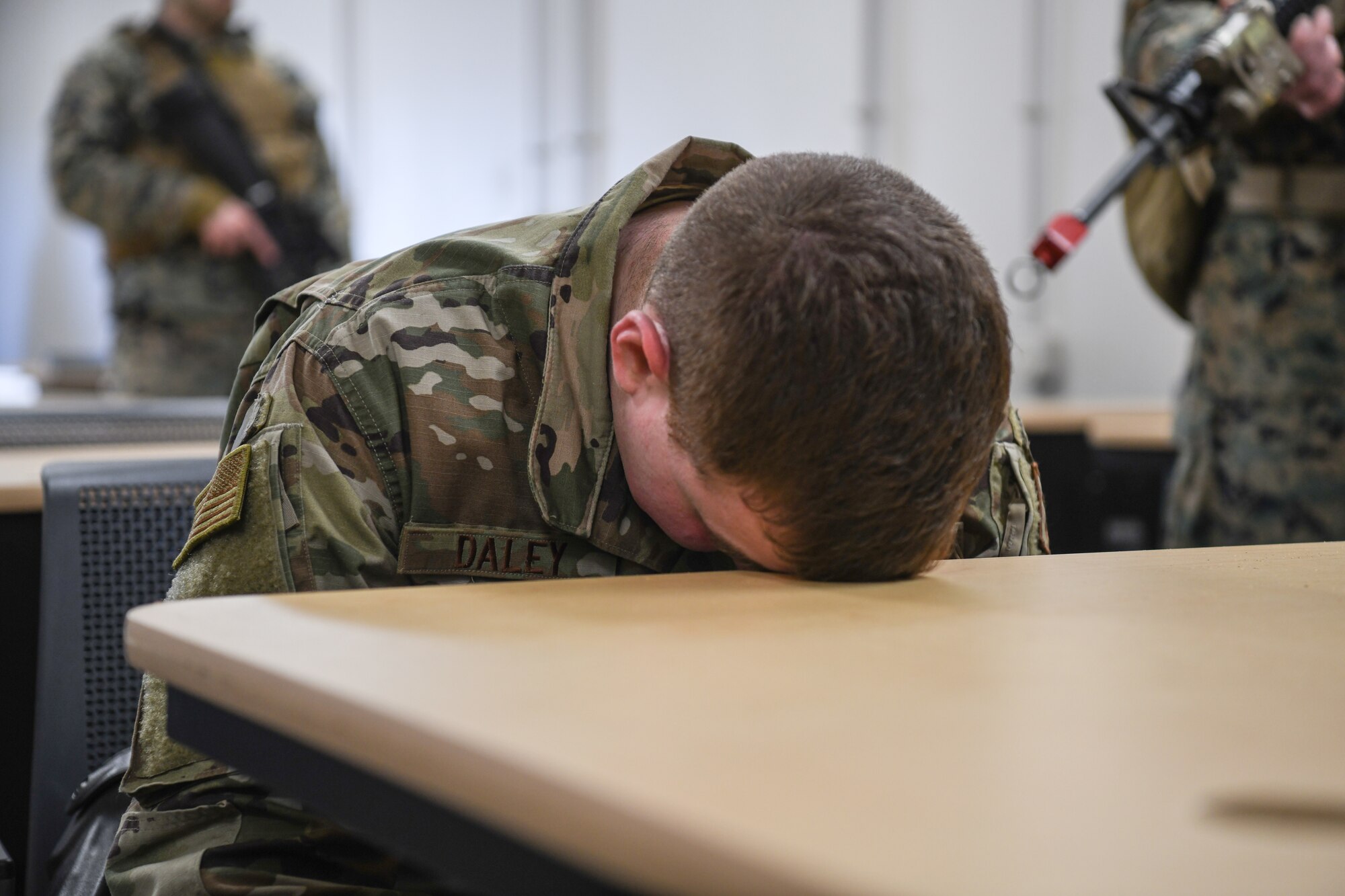 Staff Sgt. Justin Daley, 445th Security Forces Squadron, holds his head against a desk as an acting ‘detainee’ during a training exercise at the Warfighter Training Center here March 6th, 2021, Wright-Patterson Air Force Base, Ohio. Marines from Charlie Company, 4th Law Enforcement Battalion and Airmen from the 445th Security Forces Squadron participated in the detainee operations training adding elements of experience from each branch of service providing total force integration.