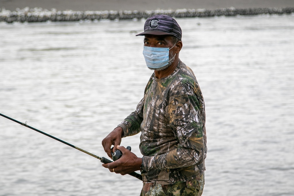 People outside along river fishing
