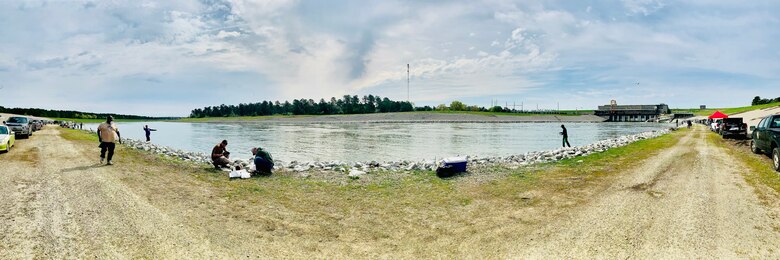 People outside along river fishing