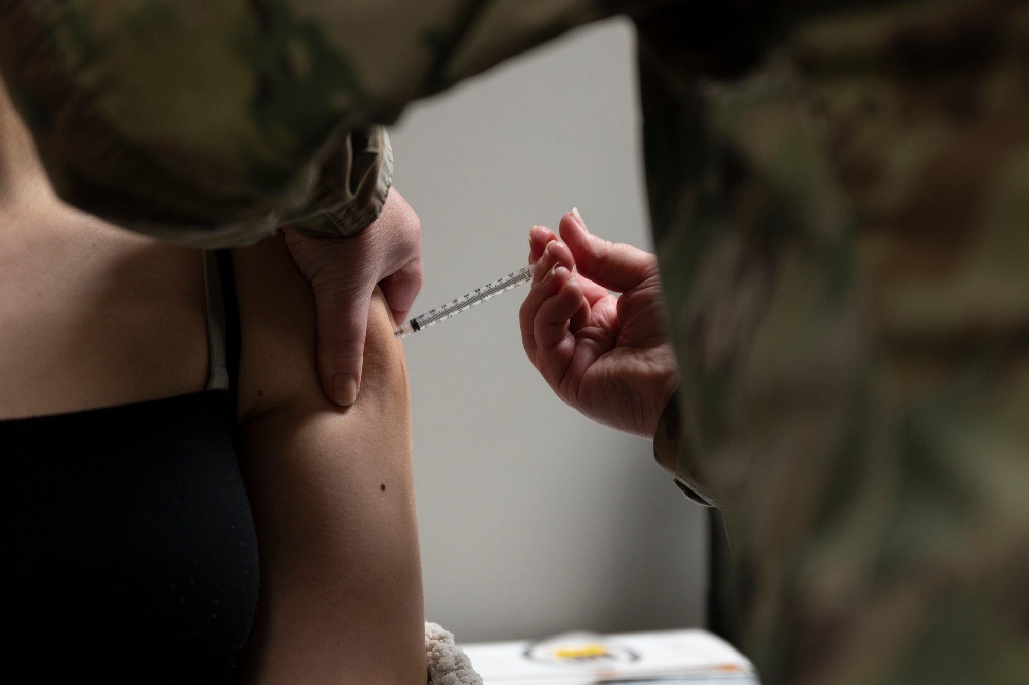 A 28th Medical Group immunization technician provides the Pfizer COVID-19 vaccine to a beneficiary during a point of distribution (POD) event at the Installation Deployment Readiness Center on Ellsworth Air Force Base, S.D., March 19, 2021. During the POD event, the 28th MDG provided approximately 1,250 beneficiaries with their first or second doses (if the first dose was provided by the 28th MDG) of the Pfizer COVID-19 vaccine within a 12-hour period. (U.S. Air Force photo by Senior Airman Christina Bennett)