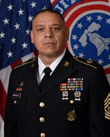 man in uniform standing in front of the USA flag and Recruiting flag.