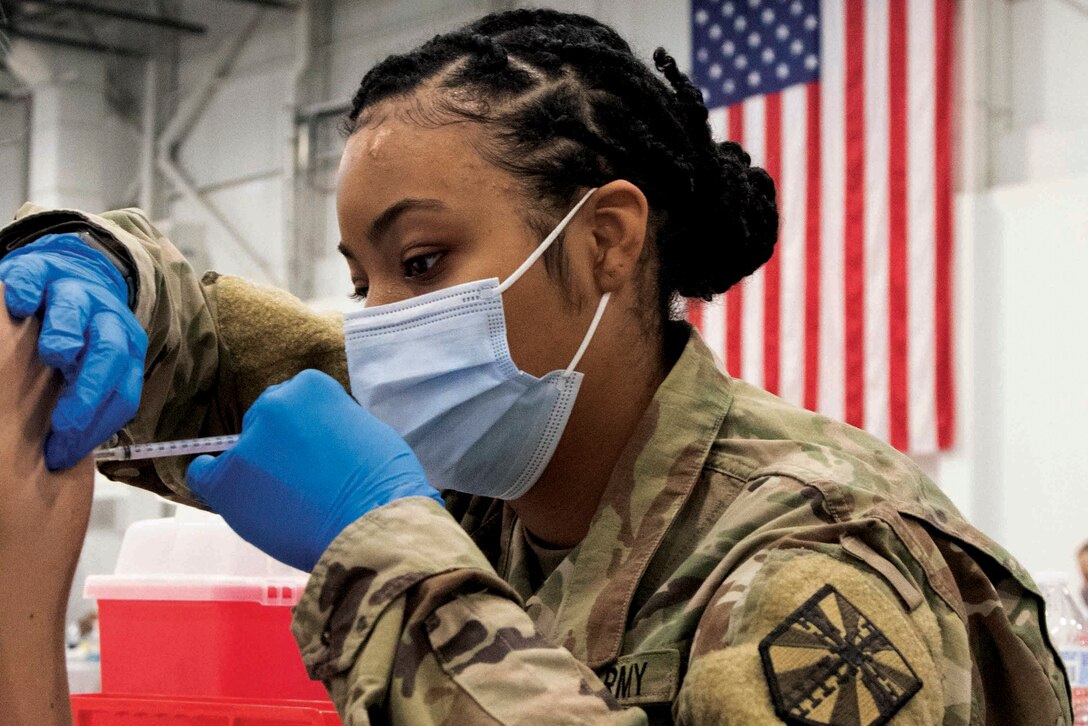 A service member administers the COVID-19 vaccine to a civilian.