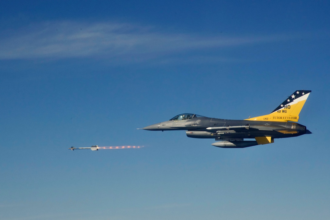 An airborne aircraft fires a missile.