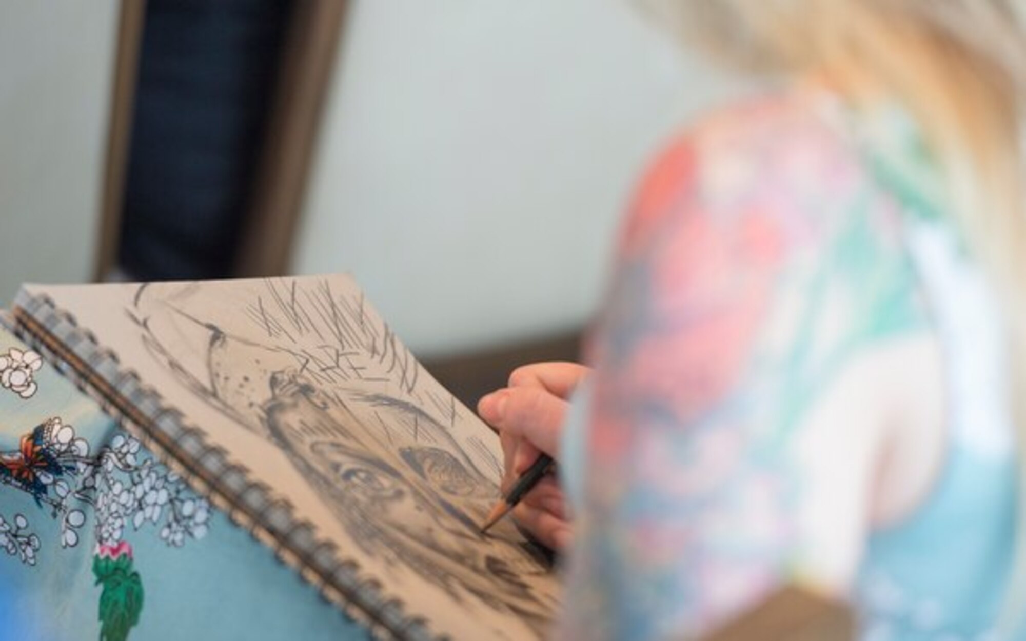 Air Force Senior Airman Adrianna Ruark works on a drawing at "A Day of Healing Arts: From Clinic to Community," an event honoring the importance of healing arts, during Warrior Care Month at National Harbor in Oxon Hill, Maryland on November 16, 2017. (DoD Photo by Roger L. Wollenberg)