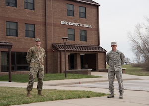 Staff Sgt. Nicholas Monteith and Master Sgt. Wade Meyer stand in front of Endeavour Hall