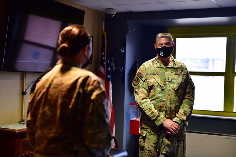 Military Training Leader provides dormitory overview to general.