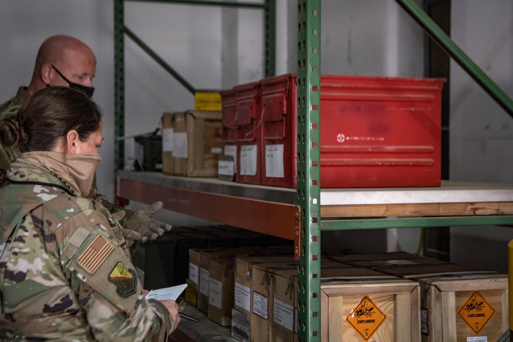 airmen inspect boxes of munitions