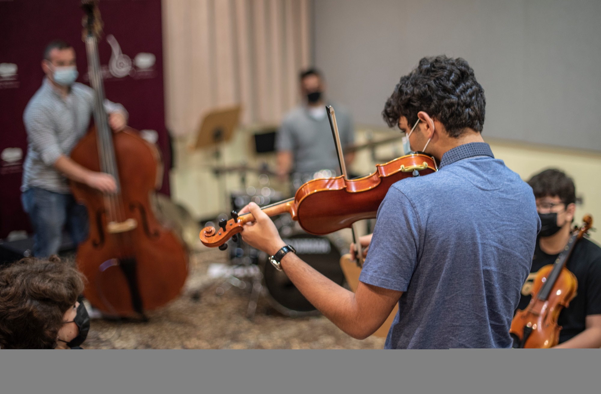 A Qatar Music Academy student improvises with the U.S. Air Forces Central Band with a specially tuned violin at the academy in Doha, Qatar, March 24, 2021. The AFCENT Band perform and tour in small ensembles throughout the region to promote positive troop morale, diplomacy and outreach to host-nation communities. (U.S. Air Force photo Tech. Sgt. Travis Edwards)