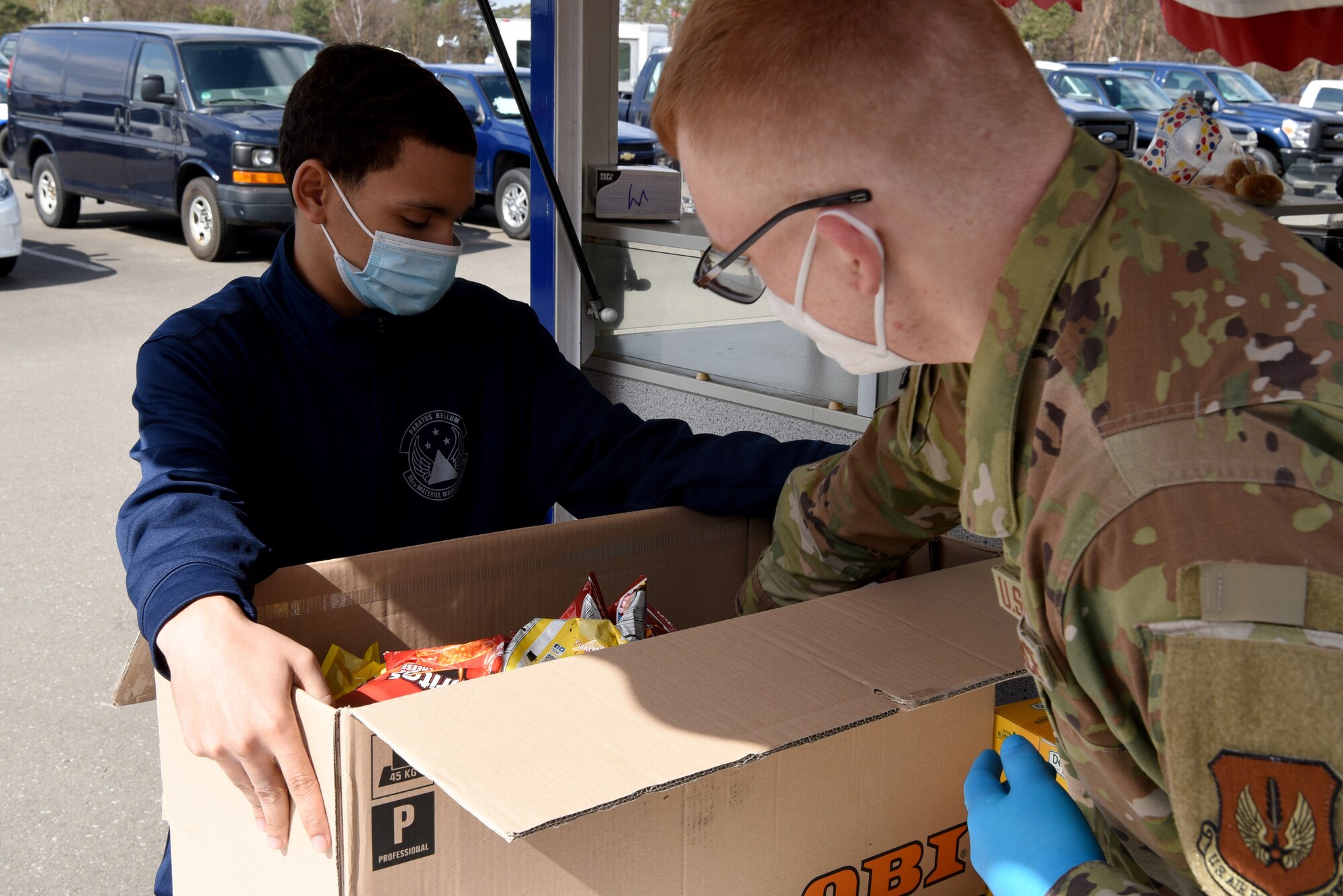 U.S. Air Force Airman 1st Class Luke Langbehn, 86th Vehicle Readiness Squadron ground transportation, right, prepares a box of lunches for fellow Airmen within the 86th Logistics Readiness Group.